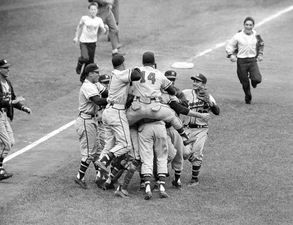 In this Oct. 10, 1957, file photo, Milwaukee Braves' Frank Torre (14) jumps on the back of pitcher Lew Burdette as the Braves celebrate their 5-0 victory over the New York Yankees in Game 7 of the World Series, in New York.