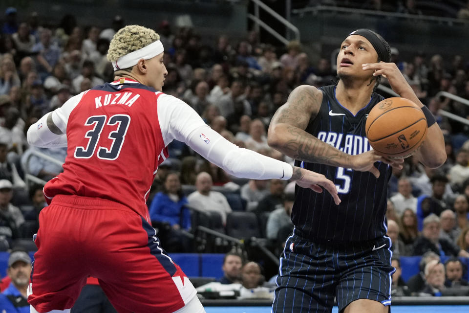 Washington Wizards forward Kyle Kuzma (33) strips the ball from the hands of Orlando Magic forward Paolo Banchero (5) during the first half of an NBA basketball game Friday, Dec. 1, 2023, in Orlando, Fla. (AP Photo/John Raoux)