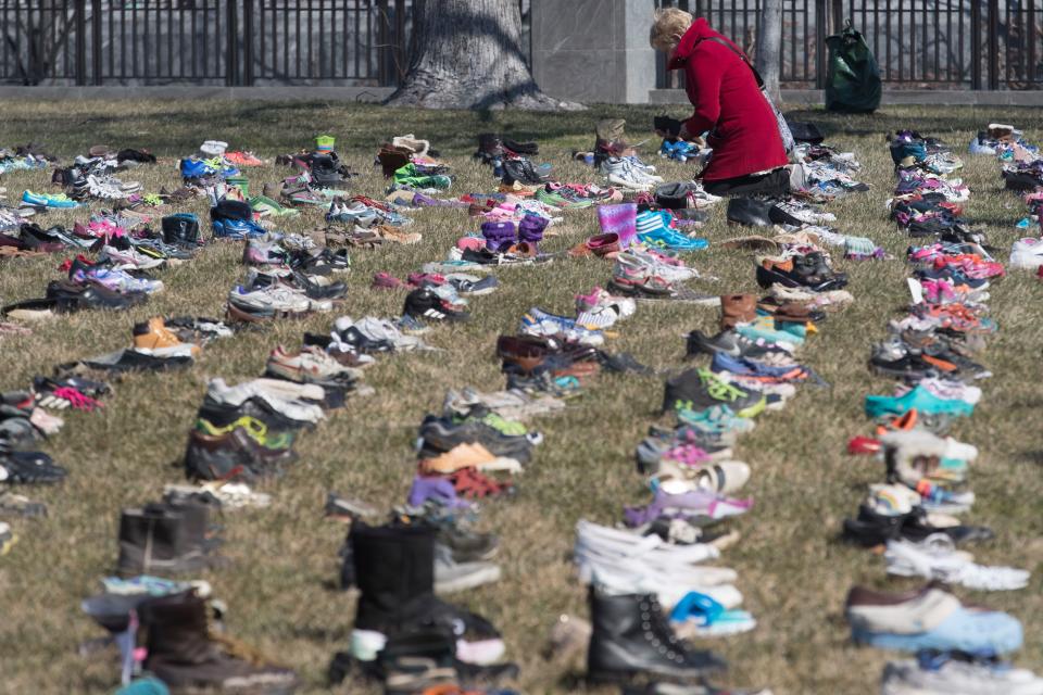 <p>A woman looks at some of the approximately seven thousand shoes representing lost children to guns since the Dec. 14, 2012 shooting at Sandy Hook Elementary School in Newtown, Conn., on the East Front of the U.S. Capitol in Washington, March 13, 2018. (Photo: Michael Reynolds/EPA-EFE/REX/Shutterstock) </p>