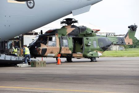 An Australian Army Taipan MRH-90 helicopter is unloaded from a Royal Australian Air Force C-17A aircraft in response to Cyclone Winston at Fiji's Nausori International Airport near Suva in this picture supplied by the Australian Defence Force, February 24, 2016. REUTERS/Australian Defence Force/Handout via Reuters