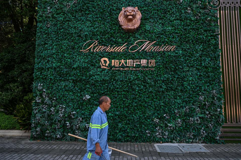 A man walks past a residential building developed by Evergrande in Pudong district in Shanghai on September 22, 2021. (Photo by Hector RETAMAL / AFP) (Photo by HECTOR RETAMAL/AFP via Getty Images)