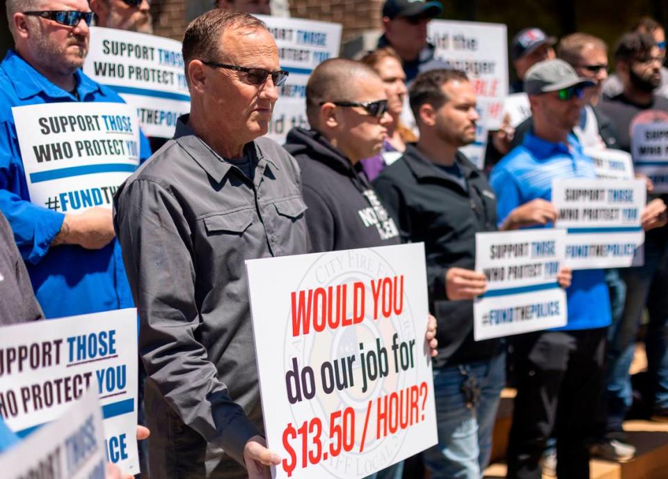 Scott Carpenter, a United Parcel driver, stands with Raleigh police and firefighters during a demonstration calling for higher wages on Tuesday, April 19, 2022 in Raleigh, N.C
