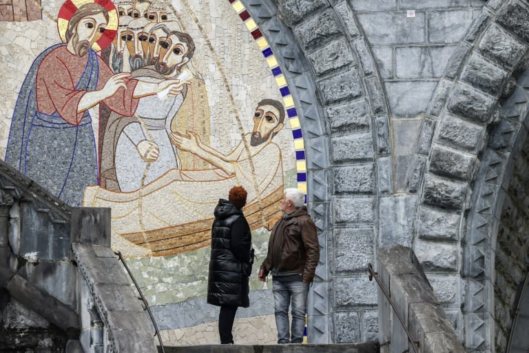 Dos personas observan un mosaico del sacerdote y artista Marko Rupnik en la Basílica de Nuestra Señora del Rosario, en el Santuario de Lourdes, en el suroeste de Francia, el 31 de marzo de 2023 (Charly Triballeau)
