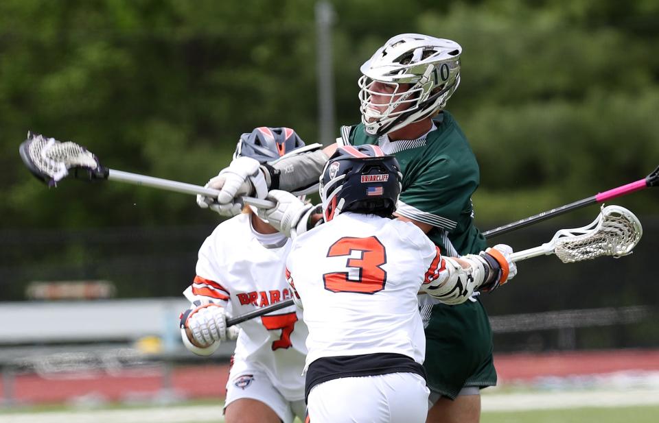 Pleasantville's Daniel Picart (10) fires a shot between Briarcliff's Luca Meola (7) and Lucas Proctor (3) during boys lacrosse action at Briarcliff High School  May 13, 2023. 
