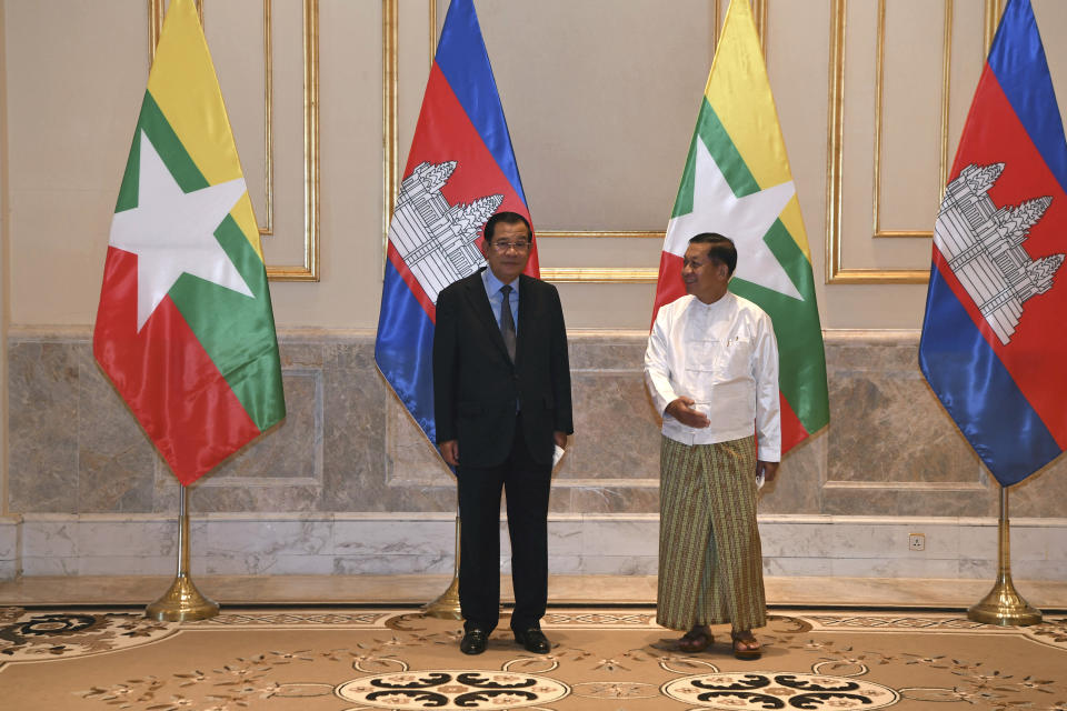 In this photo provided by An Khoun Sam Aun/National Television of Cambodia, Cambodian Prime Minister Hun Sen, left, poses for photographs together with Myanmar State Administration Council Chairman, Senior General Min Aung Hlaing, right, before holding a meeting in Naypyitaw, Myanmar, Friday Jan. 7, 2022. Cambodian Prime Minister Hun Sen's visit to Myanmar seeking to revive peace efforts after last year's military takeover has provoked an angry backlash among critics, who say he is legitimizing the army's seizure of power. (An Khoun SamAun/National Television of Cambodia via AP)