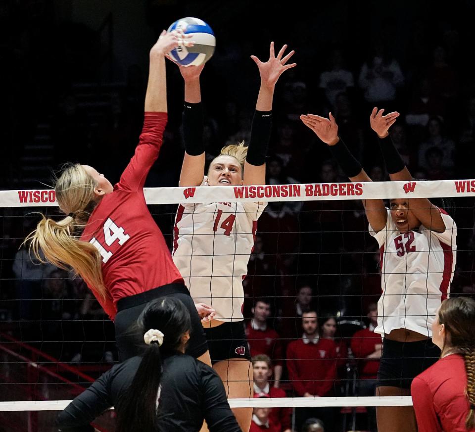 Wisconsin right-side hitter Anna Smrek and middle blocker Carter Booth (52) attempt to block the spike from Nebraska outside hitter Ally Batenhorst during the second set Friday night at the UW Field House.