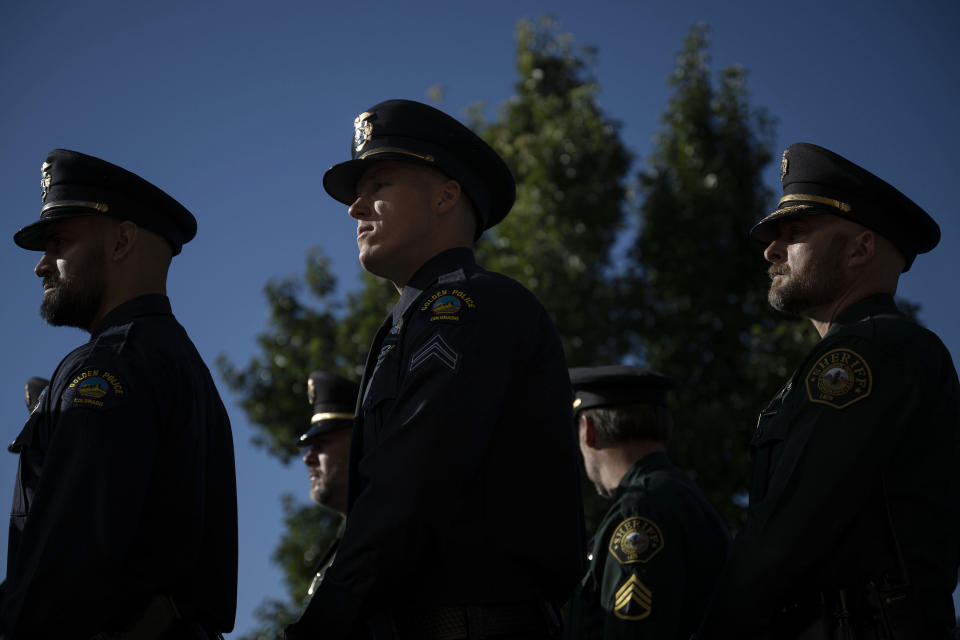 Police officers and sheriff's deputies from surrounding areas enter the church following the funeral procession for fallen Arvada Police Officer Dillon Vakoff, Friday, Sept. 16, 2022, at Flatirons Community Church in Lafayette, Colo. Vakoff was fatally shot while trying to break up a large family disturbance earlier in the week, in Arvada. (Timothy Hurst/The Gazette via AP)