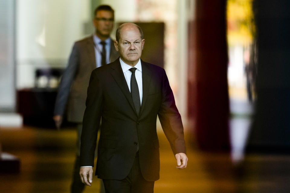 German Chancellor Olaf Scholz, center, walks through the foyer of the chancellery to welcome Spain's King Felipe VI for a meeting, Berlin, Germany, Monday, Oct. 17, 2022. German Chancellor Olaf Scholz has ordered preparations for all of the country's three remaining nuclear reactors to continue operating until mid-April 2023. The move marks another hiccup in the country's long-running plan to end the use of atomic energy. (AP Photo/Markus Schreiber)