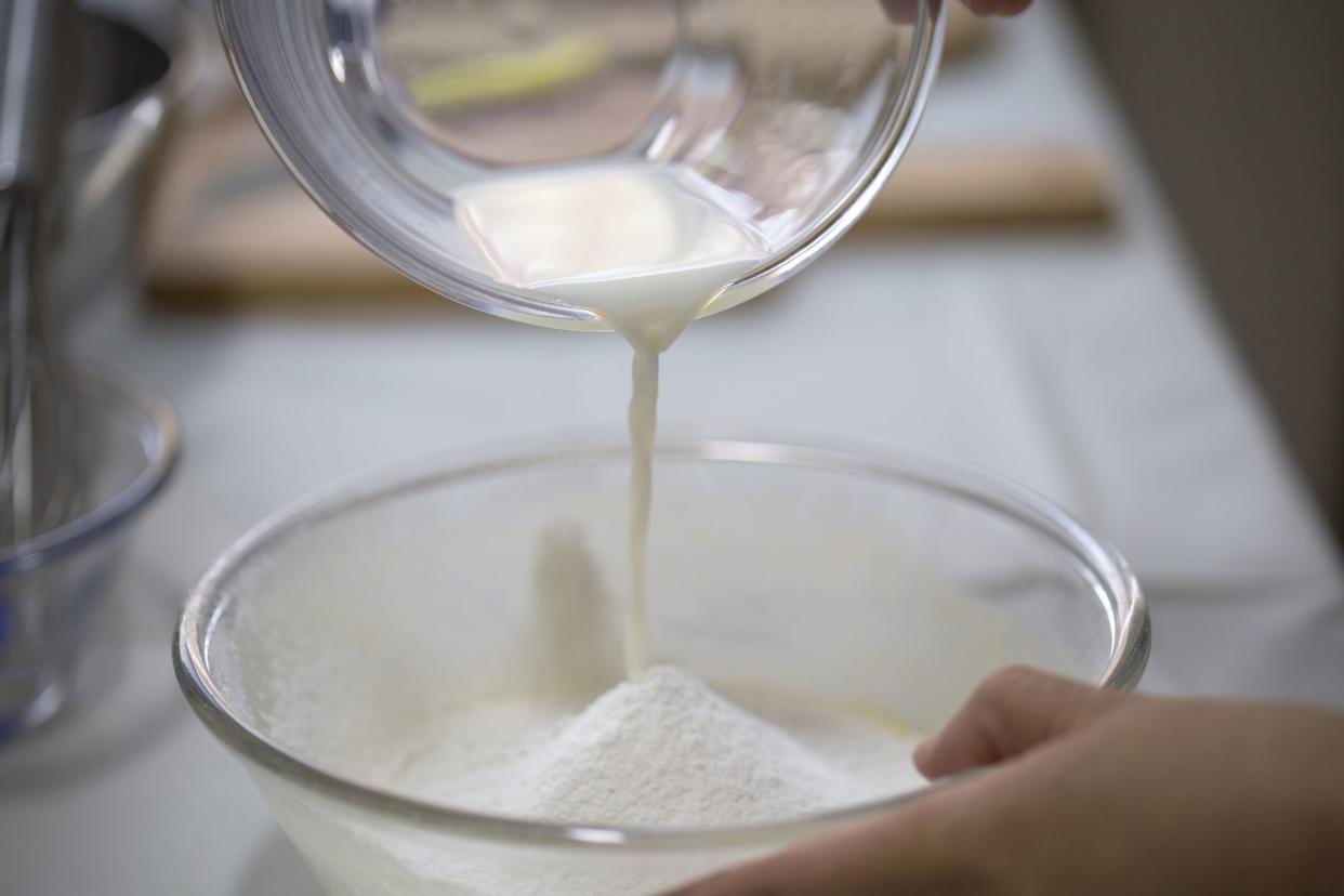 milk pouring into bowl of white powder