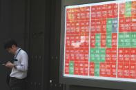 FILE - A person stands near an electronic stock board showing Japan's Nikkei index at a securities firm Wednesday, Sept. 18, 2024, in Tokyo. (AP Photo/Eugene Hoshiko, File)