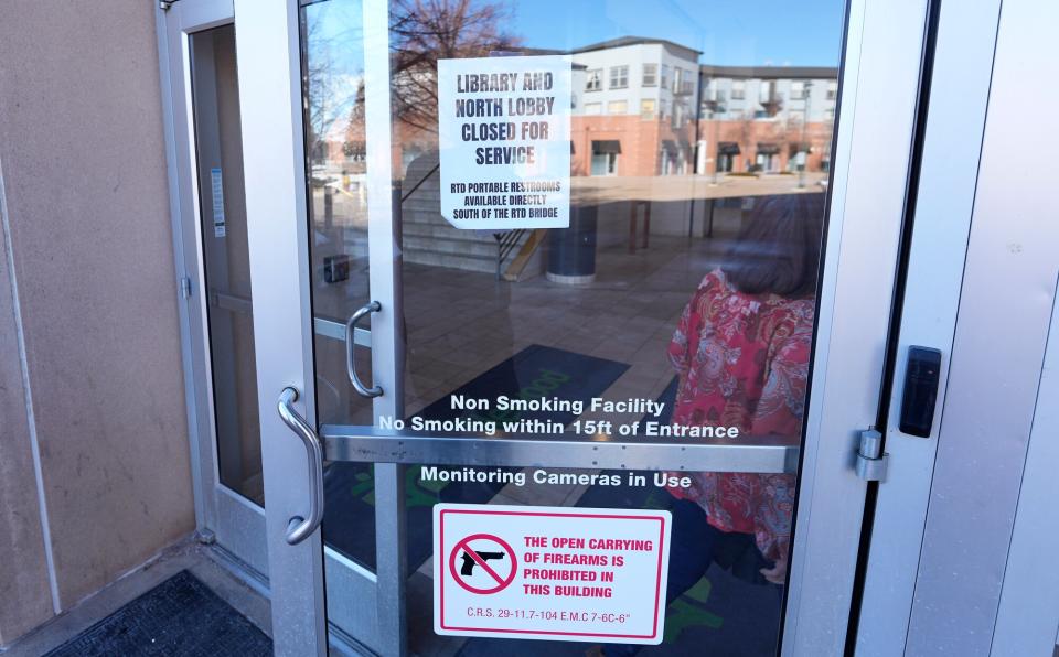 Signs are placed on the outside doors of city hall to advise visitors that the library as well as a restroom are closed because of meth contamination Thursday, Jan. 12, 2022, in the south Denver suburb of Englewood, Colo.