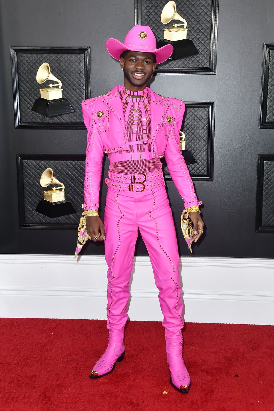 <p>For his first-ever Grammy's red carpet look, Lil Nas went full-out pretty in pink in Versace. He paired his sheer top with a cropped jacket and buckled details. Elle Woods would approve.</p>