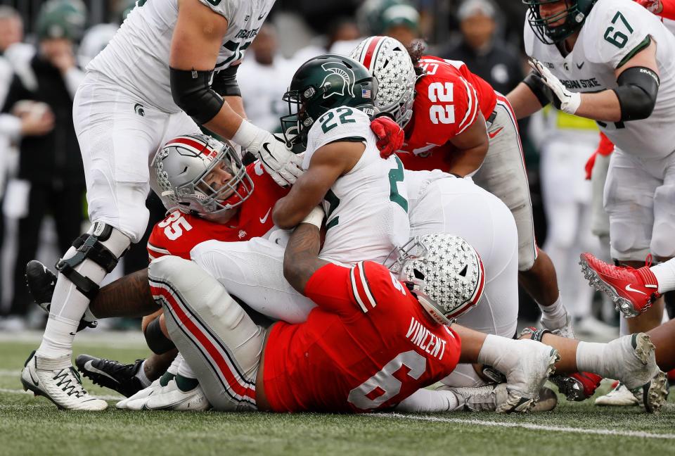 Ohio State's Taron Vincent and Tommy Eichenberg bring down Michigan State running back Jordon Simmons. The Buckeyes ranked No. 59 in total defense last year.