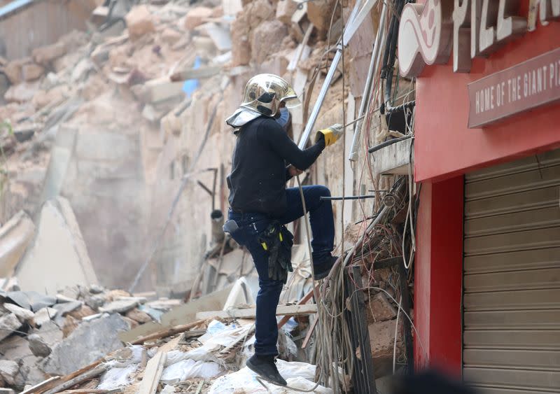 A member of the rescue team works near rubble of buildings damaged due to the massive explosion at Beirut's port area