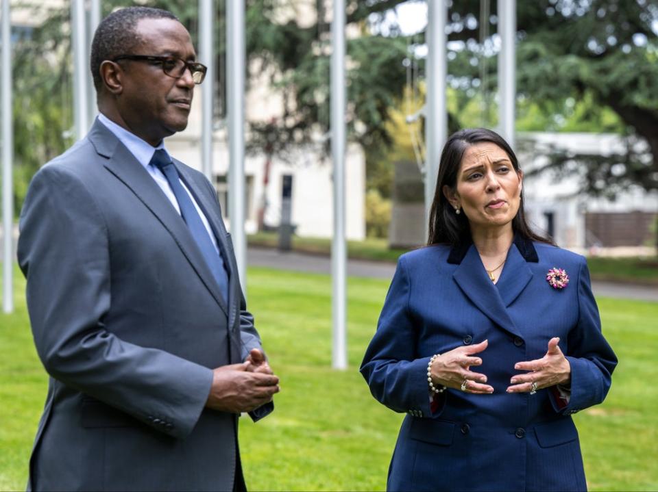 Rwandan foreign minister Vincent Biruta and home secretary Priti Patel, right, during a visit to the UN headquarters in Geneva on 19 May 2022 (AP)