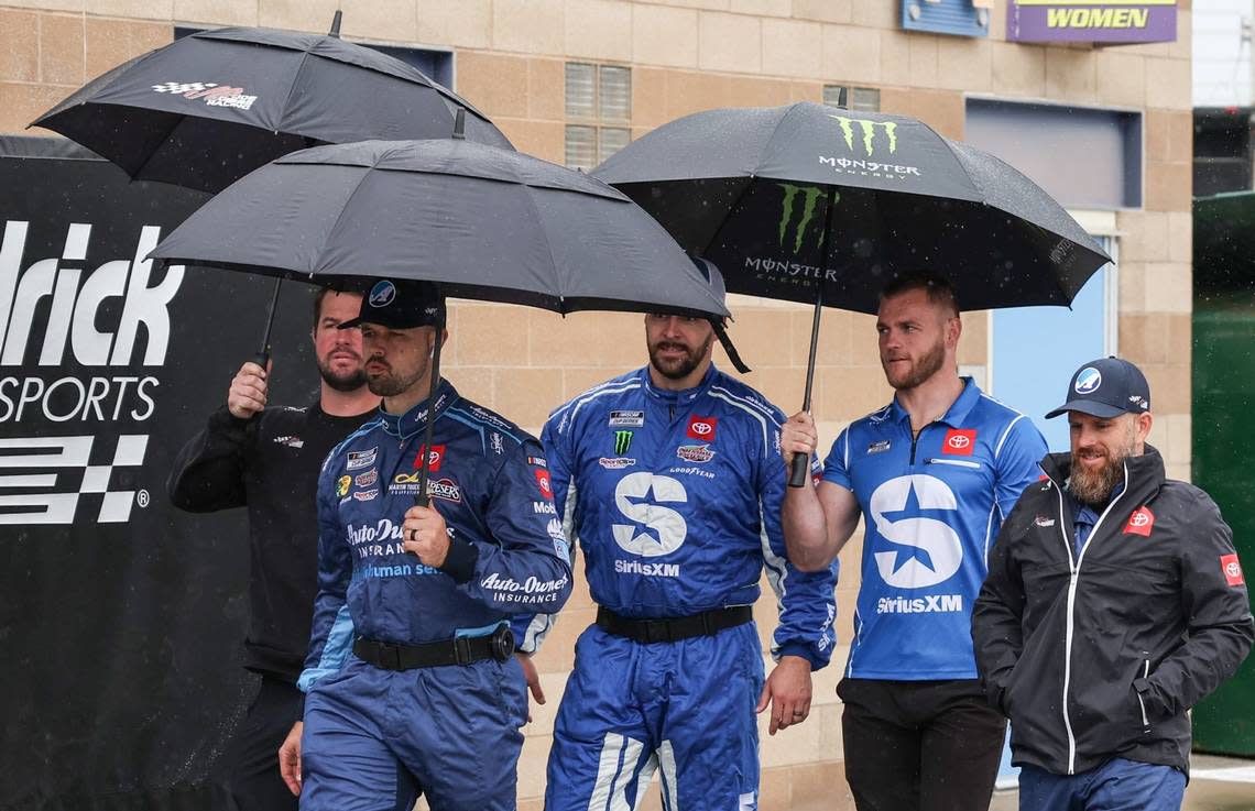 NASCAR Cup Series driver Martin Truex Jr. walks to his trailer with some team members during a pre-race rain delay at Kansas Speedway on Sunday. Reese Strickland/USA TODAY Sports