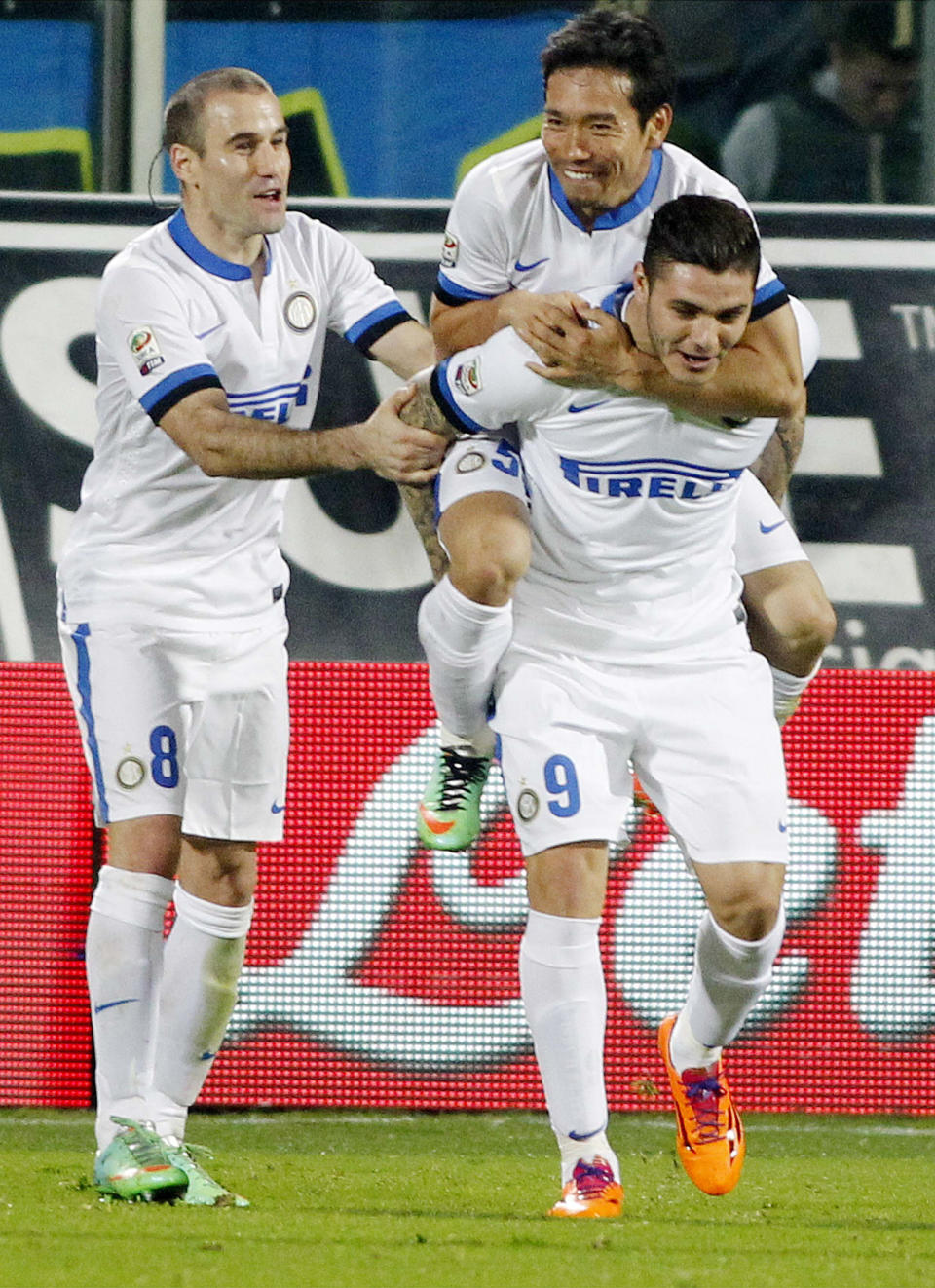 Inter Milan's Mauri Icardi, right, celebrates with teammates Rodrigo Palacio, left, and Yuto Nagatomo, on his back, after scoring during a Serie A soccer match between Fiorentina and Inter Milan, at the Artemio Franchi stadium in Florence, Italy, Saturday, Feb. 15, 2014. (AP Photo/Fabrizio Giovannozzi)