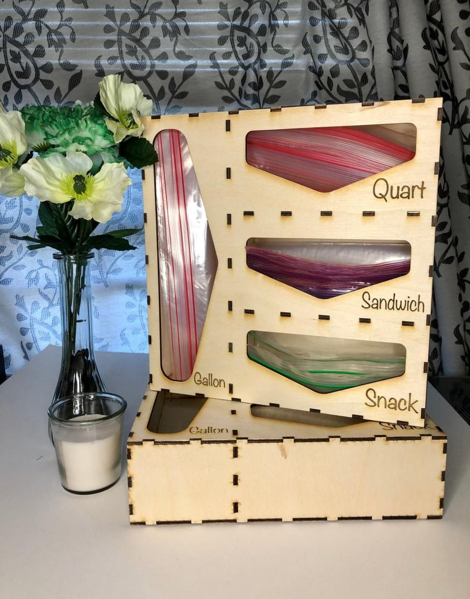 wooden organizer with slots for ziploc bags with the words quart, sandwich, snack, and gallon on it