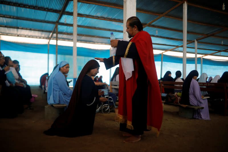 A member of the Christian evangelical church Israelite Mission of the New Universal Pact kneels before a church leader during a worship service at the group’s main temple, on the outskirts of Lima