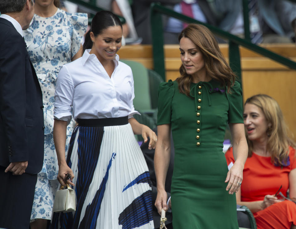 Catherine, Duchess of Cambridge and Meghan, Duchess of Sussex pictured taking their seats before the Ladies Singles Final at Wimbledon 