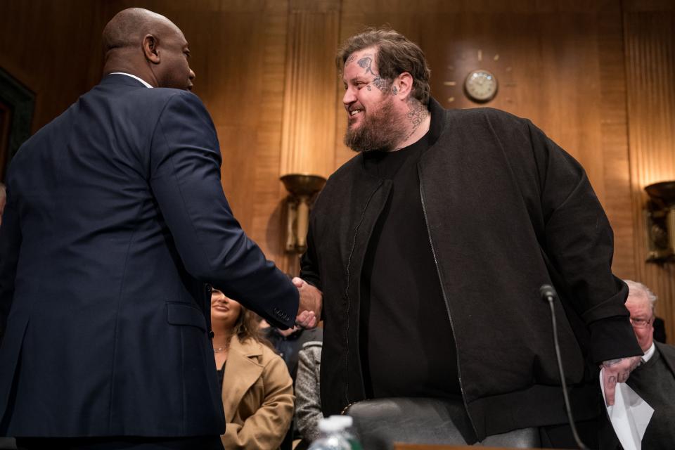 Ranking member Sen. Tim Scott (R-SC) greets American singer and songwriter Jason "Jelly Roll" DeFord before the start of a Senate Banking, Housing, and Urban Affairs committee hearing on January 11, 2024 in Washington, DC.