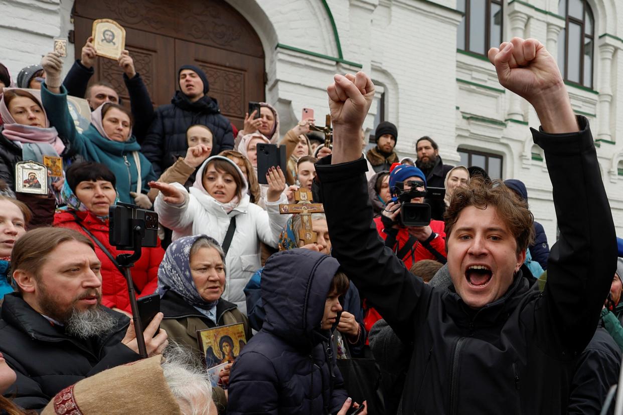 A supporter of the Orthodox Church of Ukraine argues with believers of the Ukrainian Orthodox Church, accused of being linked to Moscow, while they block an entrance to a church at a compound of the Kyiv Pechersk Lavra monastery (REUTERS)