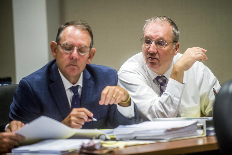 FILE - In this Aug. 22, 2018, file photo, Defendant Michael Prysby looks over paperwork with his defense attorneys at Genesee District Court in Flint, Mich. Prysby and Stephen Busch, two Michigan environmental regulators implicated in the Flint water scandal, have pleaded no contest to misdemeanors in exchange for more serious charges being dropped. (Jake May /The Flint Journal via AP, File)