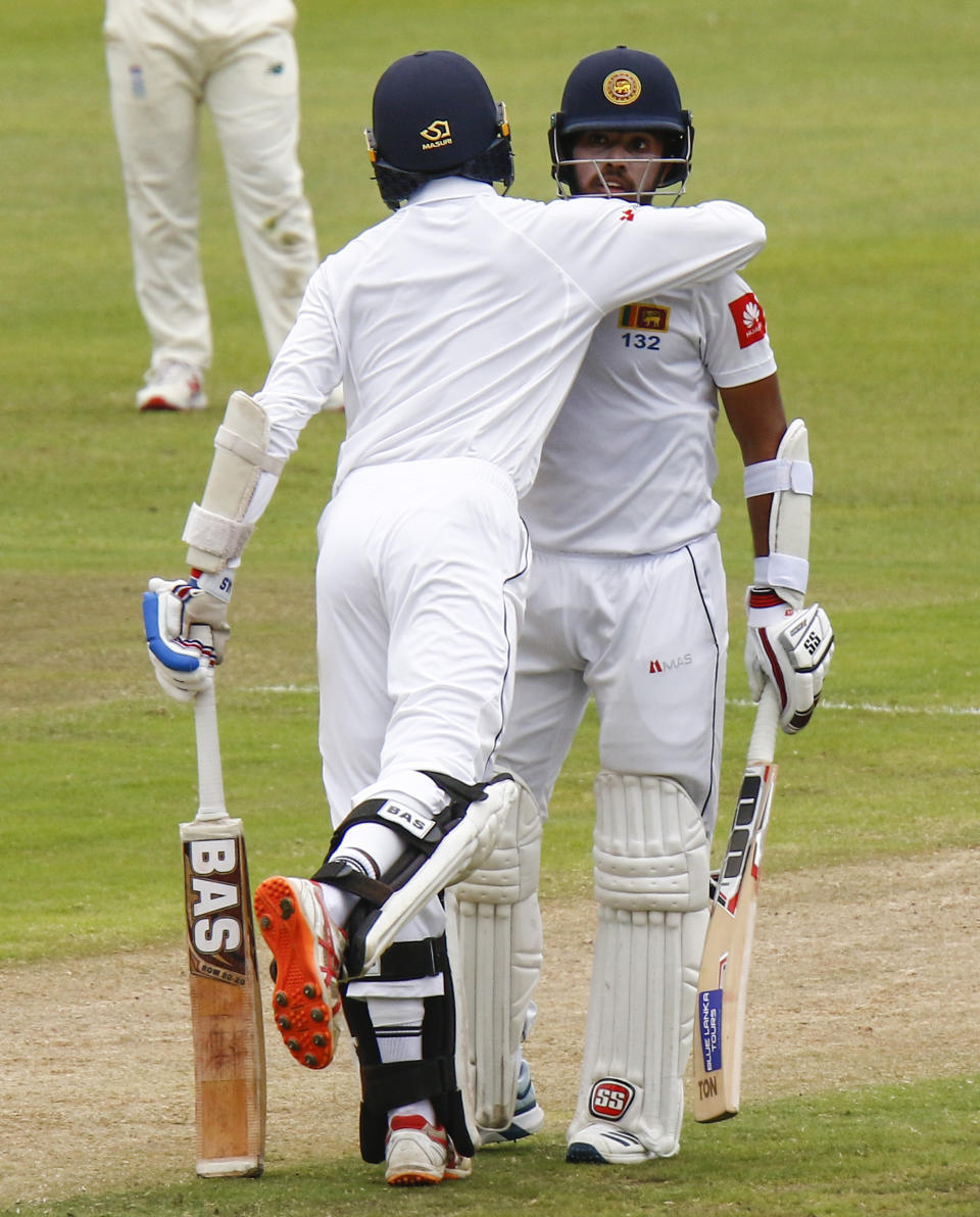 Sri Lanka's Oshada Fernando congratulates teammate Kusal Mendis on reaching 50 runs during their third day of the second cricket test at St. George's Park in Port Elizabeth, South Africa between South Africa and Sri Lanka Saturday Feb. 23, 2019. (AP Photo/Michael Sheehan)