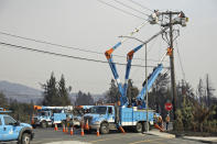 FILE - In this Oct. 11, 2017 file photo, a Pacific Gas & Electric crew works at restoring power following a wildfire along the Old Redwood Highway in Santa Rosa, Calif. An Associated Press review shows widespread problems with the four “public safety power shutoffs” the utility started rolling out in 2018, a year before massive blackouts paralyzed much of California in recent months. Interviews and documents obtained under public records requests reveal persistent failures and broken promises that in some cases compromised public safety. (AP Photo/Eric Risberg, File)