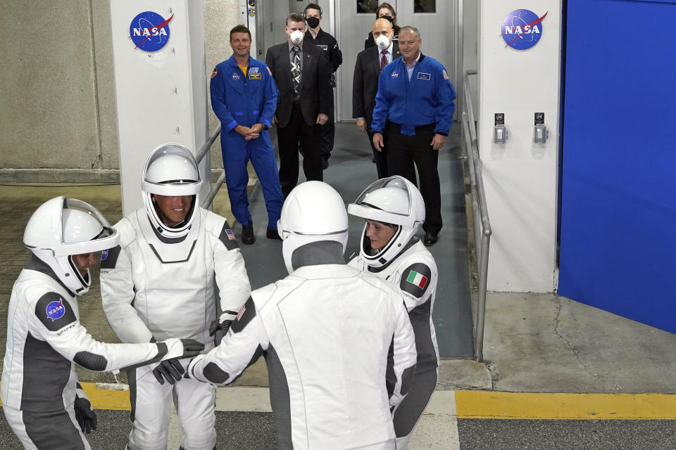 The SpaceX Crew-4 astronauts, from left, mission specialist Jessica Watkins, pilot Bob Hines, commander Kjell Lindgren, and mission specialist, European Space Agency astronaut Samantha Cristoforetti, of Italy, get together after leaving the Operations and Checkout Building for a trip to Launch Complex 39-A Wednesday, April 27, 2022, at the Kennedy Space Center in Cape Canaveral, Fla. The four astronauts will fly on SpaceX's Crew-4 mission to the International Space Station. (AP Photo/John Raoux)