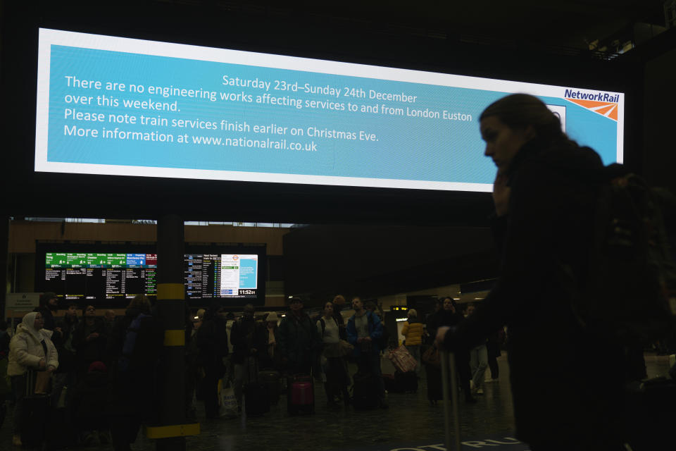 A traveller stands in front of an information display giving travel details for the upcoming Christmas holiday period at Euston Station in London, Thursday, Dec. 21, 2023. Rail travellers over the Christmas holiday season will have to contend with disruptions to services due to engineering work and bad weather. (AP Photo/Kin Cheung)