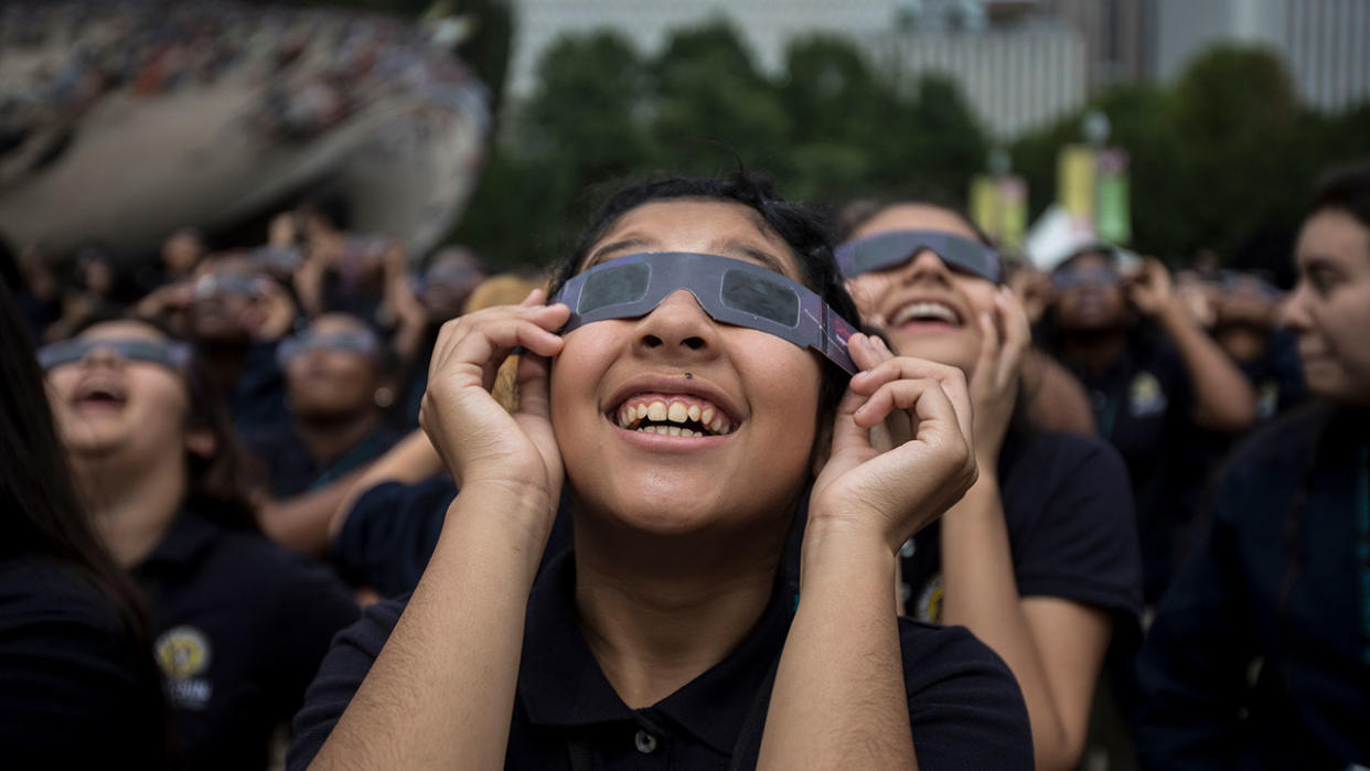  Students from Muchin College Prep react as the solar eclipse emerges from behind clouds in Millennium Park in Chicago on Aug. 21, 2017. 