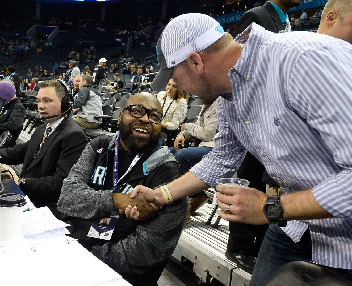 Charlotte Hornets PA announcer Pat Doughty on left, shakes hands with Hornets fan Jason Hames of Charlotte on right, Hames was welcoming Pat Doughty back after a brief absence, during Monday night’s game against San Antonio Spurs played at Time Warner Cable Arena March 21, 2016.