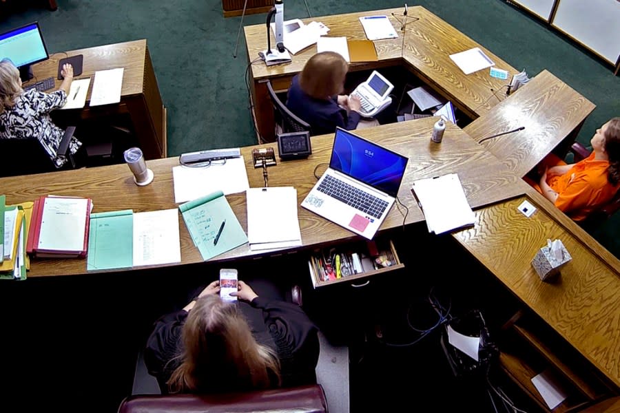 In this image from security camera video, Lincoln County District Judge Traci Soderstrom looks at her cellphone during a murder trial, June 12, 2023, at the Lincoln County District Court in Chandler, Okla. (Lincoln County District Court/The Oklahoman via AP, File)