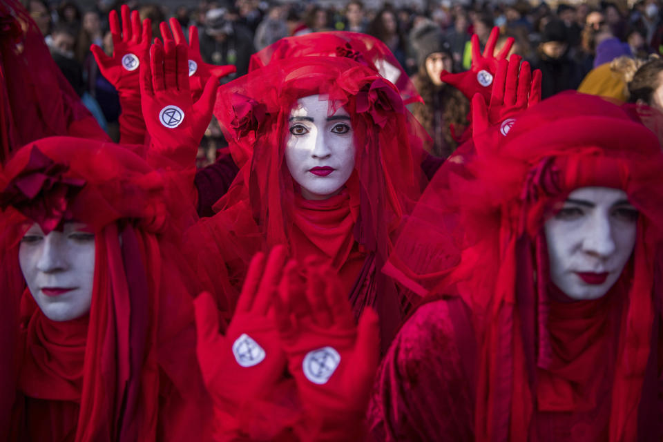 Activists of Extinction Rebellion sport red clothes as they demonstrate with other young environmentalists to demand measures against climate change in front of the Parliament building in Budapest, Hungary, Friday, Nov. 29, 2019. The protest was held by the movements Fridays For Future Hungary and Extinction Rebellion Hungary. (Zoltan Balogh/MTI via AP)