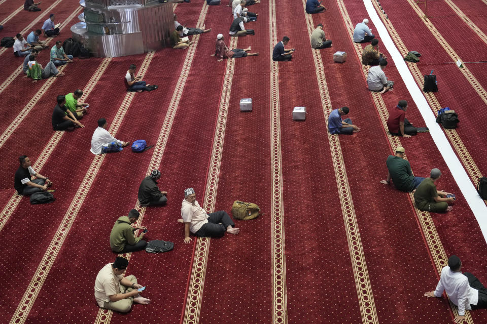 Muslim reads the Quran while waiting for the time break their fast during the first day of Ramadan at the Istiqlal Mosque in Jakarta, Indonesia, Tuesday, March 12, 2024. (AP Photo/Achmad Ibrahim)