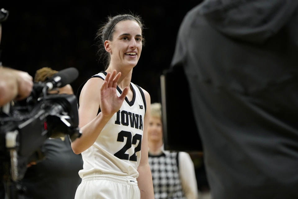 Iowa guard Caitlin Clark (22) smiles after breaking the NCAA women's career scoring record during the first half of the team's college basketball game against Michigan, Thursday, Feb. 15, 2024, in Iowa City, Iowa. (AP Photo/Matthew Putney)