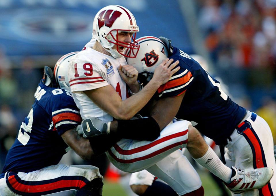 Wisconsin quarterback Jim Sorgi (19) gets sandwiched by Auburn defenders Reggie Torbor and Karlos Dansby, causing him to fumble in the fourth quarter. Auburn defeated Wisconsin 28-14 before 55,109 in the Music City Bowl in Nashville Dec. 31, 2003. Credit: Sanford Myers / The Tennessean-Imagn Content Services, LLC