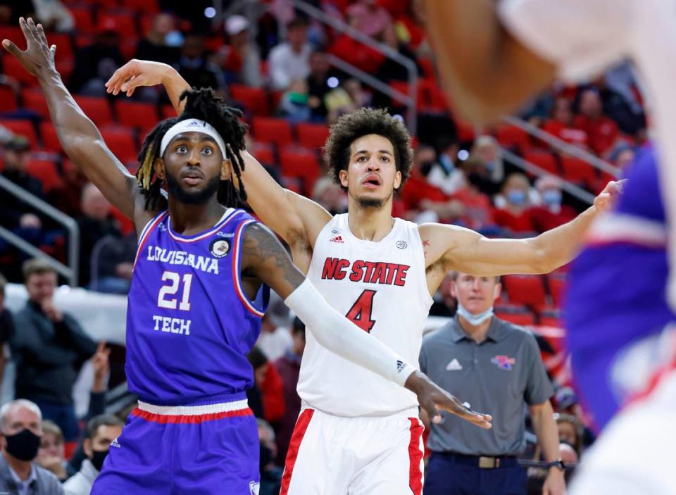 N.C. State’s Jericole Hellems (4) watches his three-pointer go in during the first half of N.C. State’s game against Louisiana Tech at PNC Arena in Raleigh, N.C., Saturday, November 27, 2021. Louisiana Tech’s Exavian Christon (21) also watches.