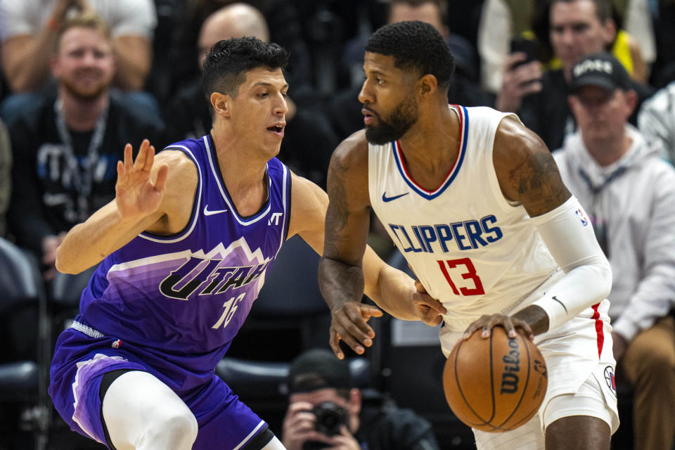 Utah Jazz forward Simone Fontecchio, left, defends as Los Angeles Clippers forward Paul George (13) makes a move to the basket during the first half of an NBA basketball game Friday, Dec. 8, 2023, in Salt Lake City. (AP Photo/Rick Egan)