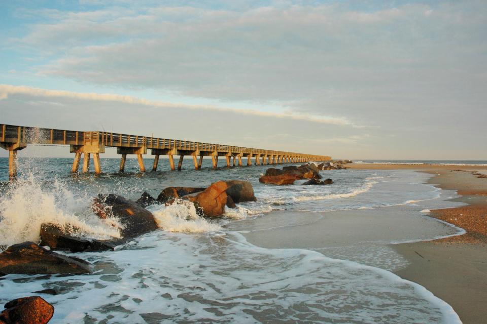 Waves crashing against breakers along the pier on the northern end of Amelia Island, Florida