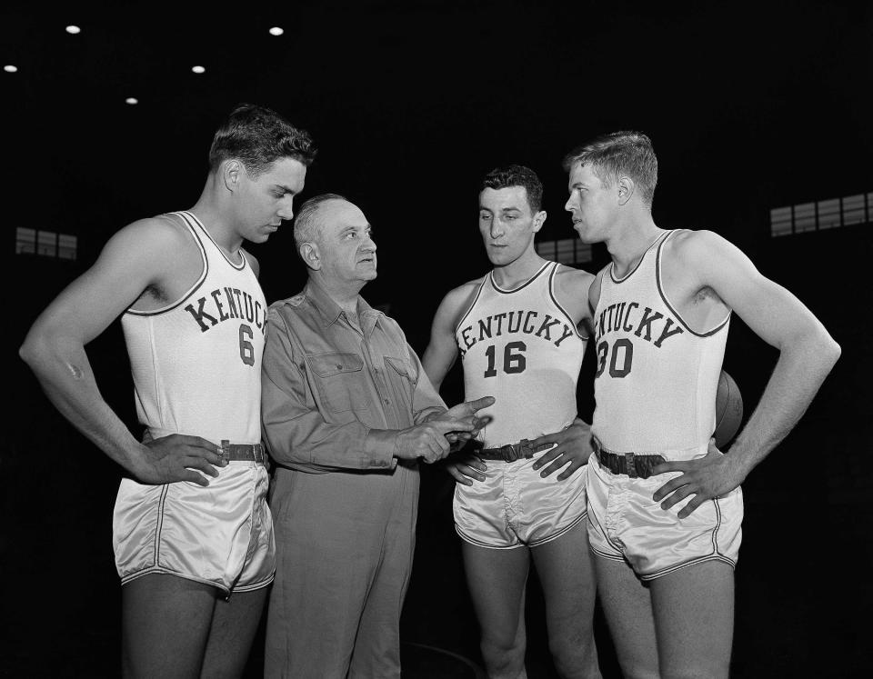 FILE - Kentucky basketball coach Adolph Rupp talks to players, from left, Cliff Hagan, Lou Tsioropoulos and Frank Ramsey (30) in Lexington, Ky., Jan. 16, 1954. (AP Photo/John Wyatt, File)