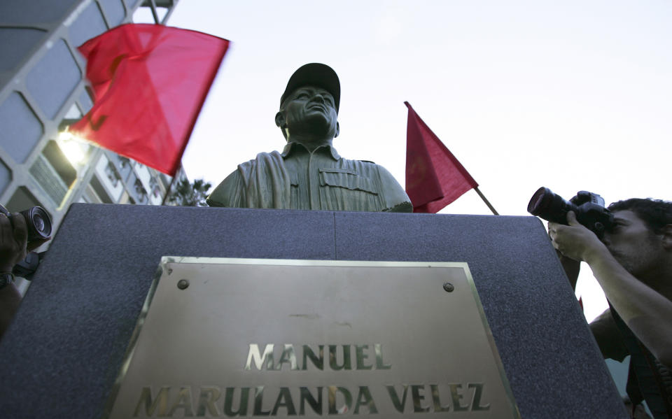 FILE - In this Sept. 26, 2008 file photo, photographers take pictures of a bust of the late Manuel Marulanda, the founding leader of the Revolutionary Armed Forces of Colombia, or FARC, unveiled by members of the Venezuela's Communist Party in a plaza in the Caracas' 23 de Enero neighborhood of Caracas, Venezuela. Colombian news magazine Semana reported on Sunday, Sept. 8, 2019 that leaked intelligence reports indicate Venezuelan President Nicolas Maduro’s socialist government is harboring Colombian rebels inside Venezuela, and Colombian officials say the information coincides with allegations they will present in Sept. 2019 to the U.N. (AP Photo/Fernando Llano, File)