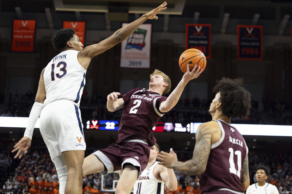 Texas A&M's Hayden Hefner (2) goes for a shot defended by Virginia's Ryan Dunn (13) during the first half of an NCAA college basketball game in Charlottesville, Va., Wednesday, Nov. 29, 2023. (AP Photo/Mike Kropf)