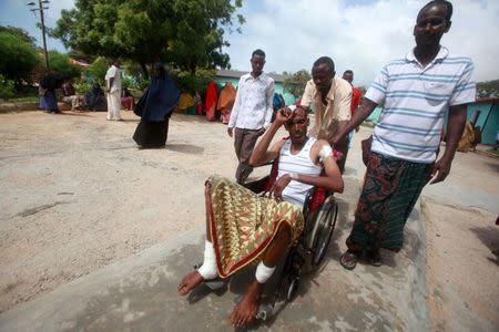 A man injured in a suicide bomb attack at Hotel Nasahablood is pushed on a wheelchair as he arrives to receive treatment at a hospital in Somalia's capital Mogadishu, June 26, 2016. REUTERS/Ismail Taxta