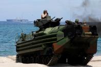 FILE PHOTO: With the USS-Wasp in the background, U.S. Marines ride an amphibious assault vehicle during the amphibious landing exercises of the U.S.-Philippines war games promoting bilateral ties at a military camp in Zambales province