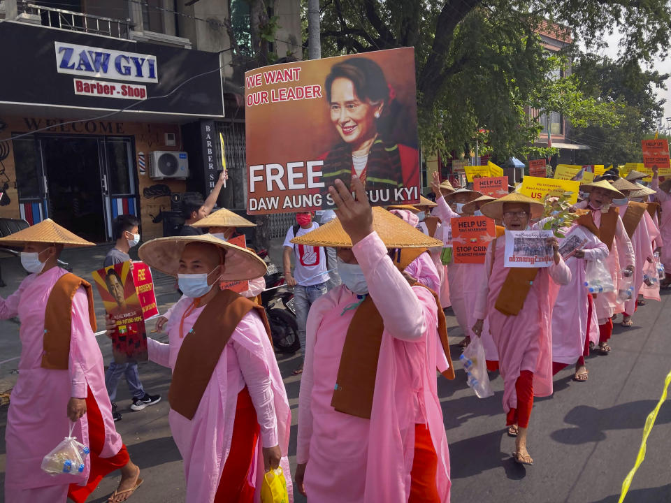 Buddhist nuns display images of deposed Myanmar leader Aung San Suu Kyi during a street march in Mandalay, Myanmar, Friday, Feb. 26, 2021. Tensions escalated Thursday on the streets of Yangon, Myanmar's biggest city, as supporters of Myanmar's junta attacked people protesting the military government that took power in a coup, using slingshots, iron rods and knives to injure several of the demonstrators. (AP Photo)