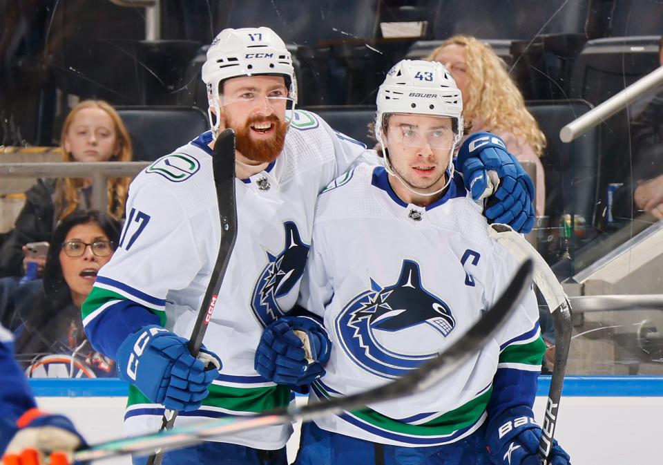 Filip Hronek and Quinn Hughes of the Vancouver Canucks celebrate Hughes first period goal against the New York Islanders at UBS Arena on Jan. 9, 2024 in Elmont, New York.