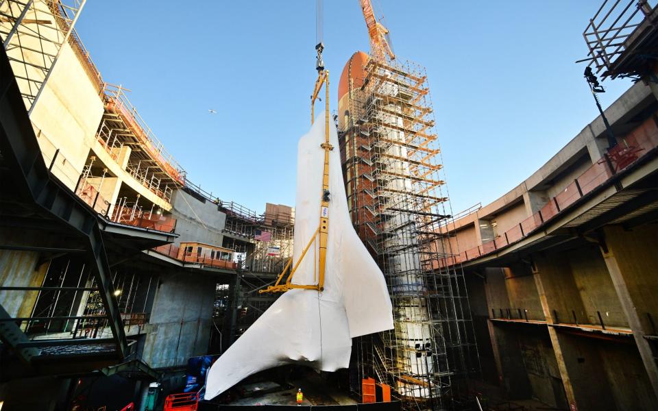 Endeavour stands in a vertical position beside two rocket boosters and the external tank