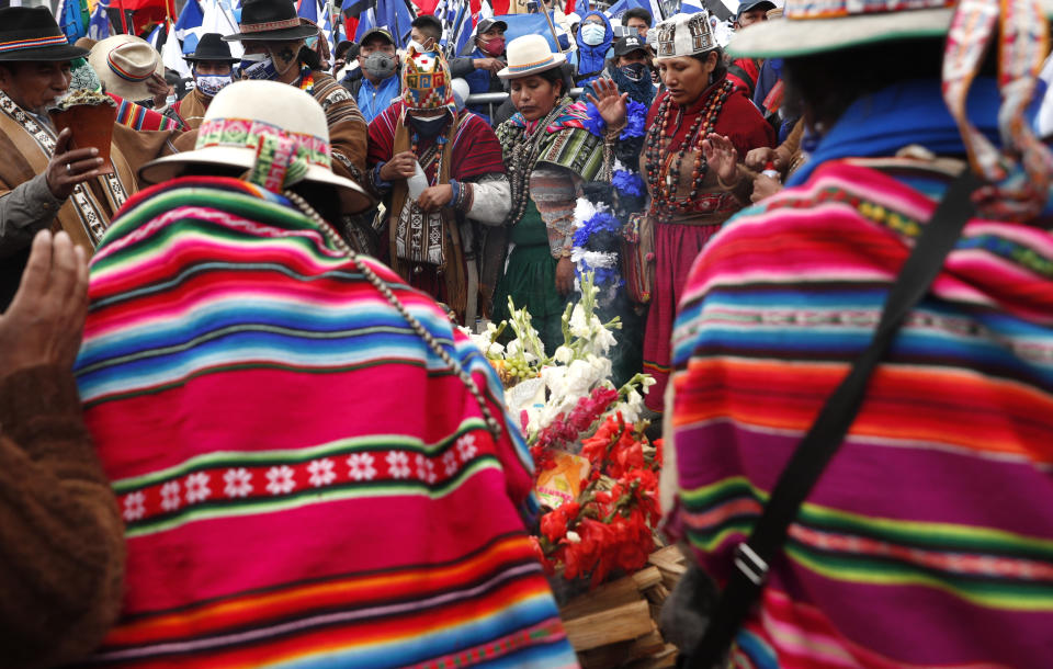 Supporters of presidential candidate Luis Arce from the Movement Towards Socialism Party, MAS, surround an offering to the "Pachamama," or Mother Earth during his closing campaign rally in El Alto, Bolivia, Wednesday, Oct. 14, 2020. Elections will be held Oct. 18. (AP Photo/Juan Karita)